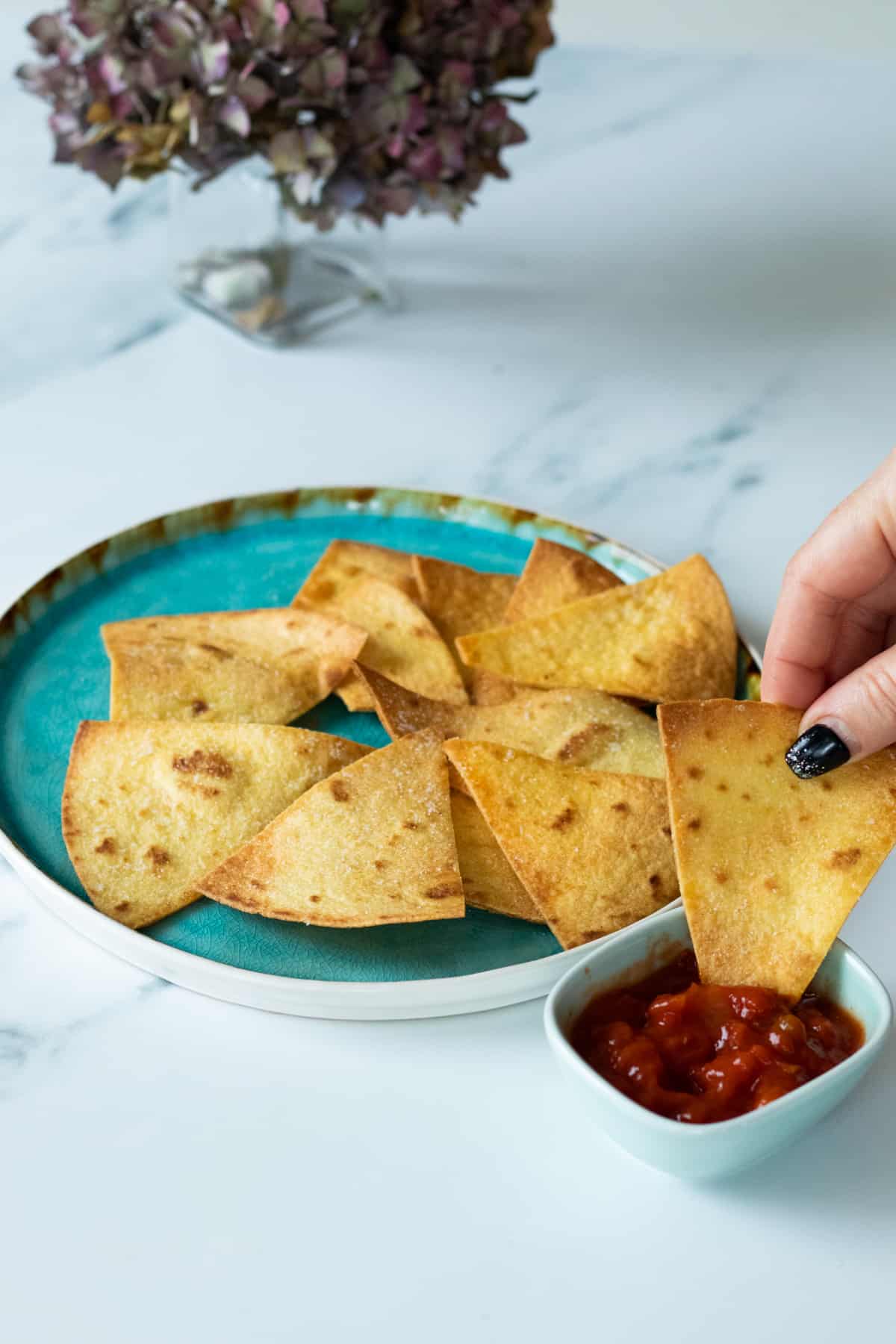 une chips de tortilla maison trempée dans de la salsa